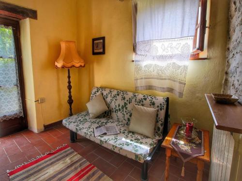 a living room with a couch and a lamp at Farmhouse with stables, horses and the ability to make horseback riding in Monte Santa Maria Tiberina