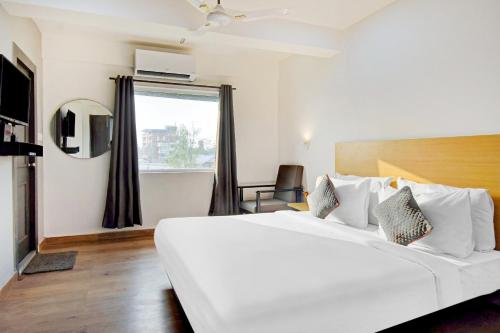 a large white bed in a room with a window at Super Townhouse The Royal Retreat in Kolkata