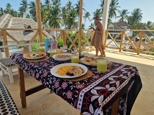 a table with plates of food on top of a table at ZamZam House in Jambiani