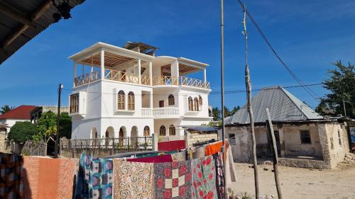 a white house with a clothes line in front of it at ZamZam House in Jambiani