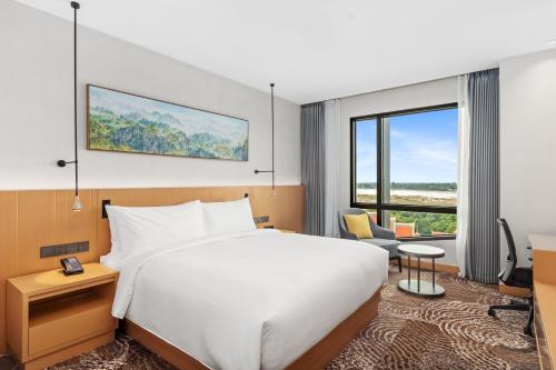 a hotel room with a bed and a large window at DoubleTree by Hilton Vientiane in Vientiane