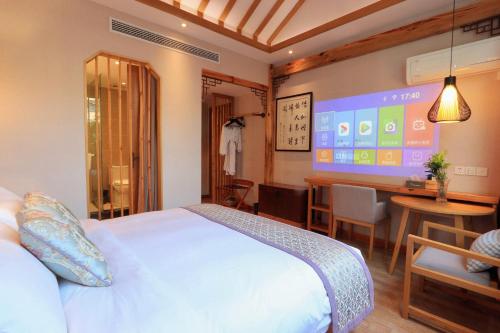 a hotel room with a bed and a table and a screen at Mild Spring Boutique Hotel in Huangshan