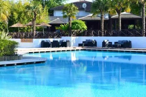 a large pool with blue water in front of a building at Camping 5 étoiles - Parc aquatique - eebdba in Mézos