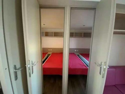 a room with two closets with a red bed at Camping 5 étoiles - Parc aquatique - eebdba in Mézos