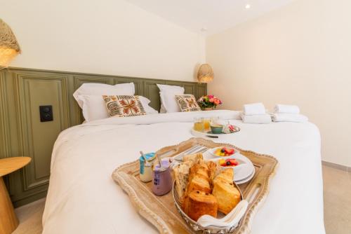 a tray of sandwiches and bread on a bed at Les Capucines Saint Tropez in Saint-Tropez