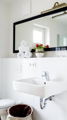 a white bathroom with a sink and a mirror at Zweitraum in Oldenburg in Oldenburg