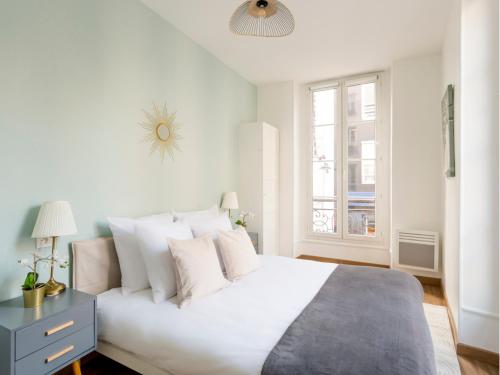 une chambre blanche avec un lit blanc et une fenêtre dans l'établissement Merveil - Family Suite - Opera - Caumartin I, à Paris
