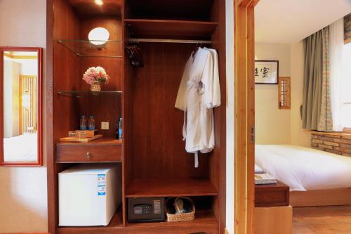 a room with a bedroom with a bed and a closet at Mild Spring Boutique Hotel in Huangshan