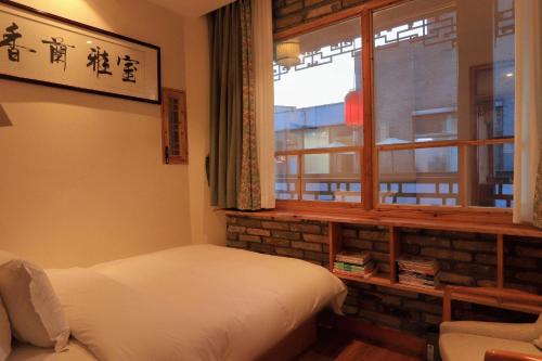 a bedroom with a bed and a window at Mild Spring Boutique Hotel in Huangshan