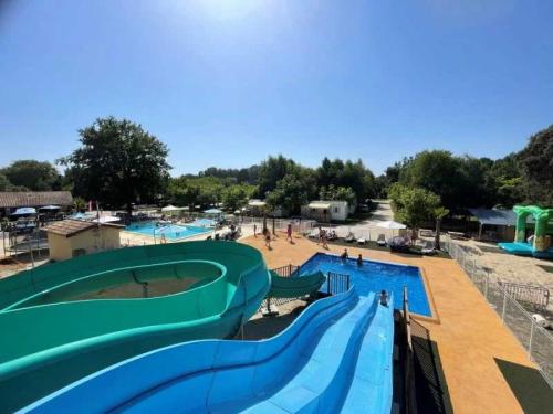une grande piscine avec toboggan dans un parc aquatique dans l'établissement Camping 4 étoiles - Piscine - eehafi, à Grayan-et-lʼHôpital