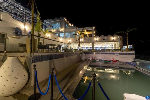 une maison avec piscine la nuit dans l'établissement Terra Bliss Lake Bhimtal Resort And Spa, à Bhimtal