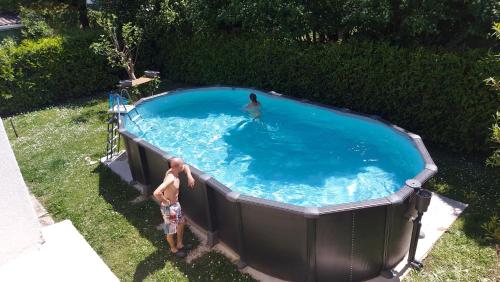 un homme se tient dans une grande piscine dans l'établissement Chambre d'hôte, à Bon-Encontre