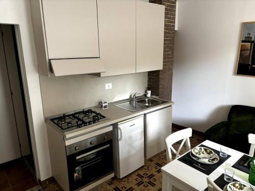 Una pequeña cocina con estufa y fregadero. en Charming Umbrian Apartment in Castel Viscardo, en Castel Viscardo