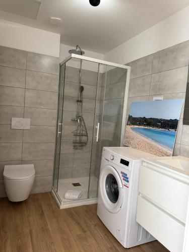 une machine à laver dans une salle de bain avec douche dans l'établissement T4 Fior di Cala Rossa by Pinarello Villa Services, à Lecci