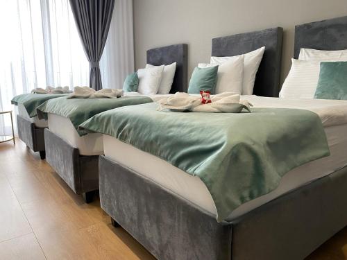 two beds in a room with green and white sheets at Hotel GOLD JET Bihać in Bihać