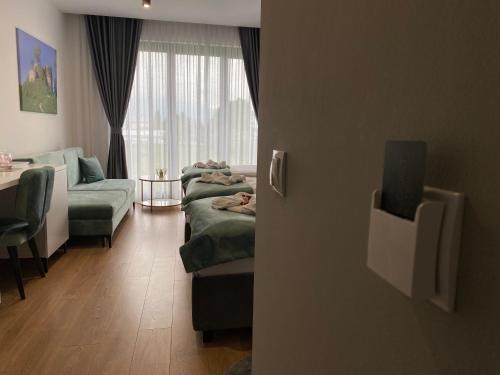 a room with couches and a table and a window at Hotel GOLD JET Bihać in Bihać