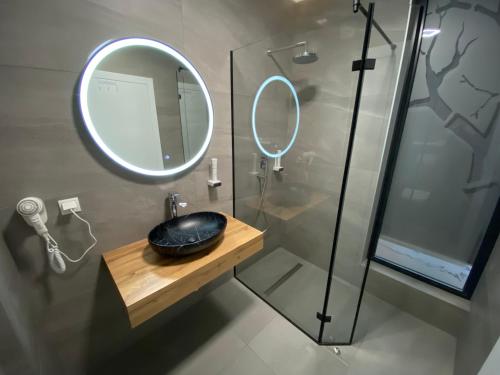 a bathroom with a mirror and a sink and a shower at Hotel GOLD JET Bihać in Bihać