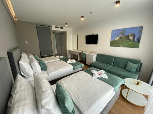 a hotel room with two beds and a couch at Hotel GOLD JET Bihać in Bihać