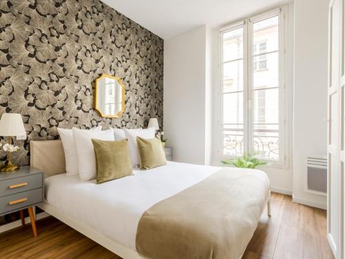 - une chambre avec un grand lit et un mur recouvert de fleurs dans l'établissement Merveil - Family Suite - Opera - Caumartin II, à Paris