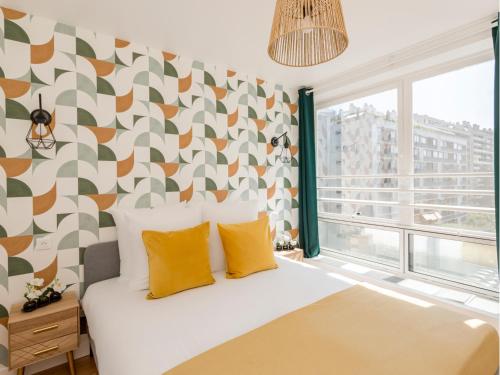 une chambre avec un lit avec des oreillers jaunes dans l'établissement Merveil - Family Suite - Tour Eiffel - Finlay, à Paris