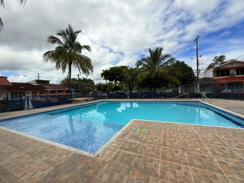 a large blue swimming pool with palm trees in the background at Casa Alicante Girardot in Girardot