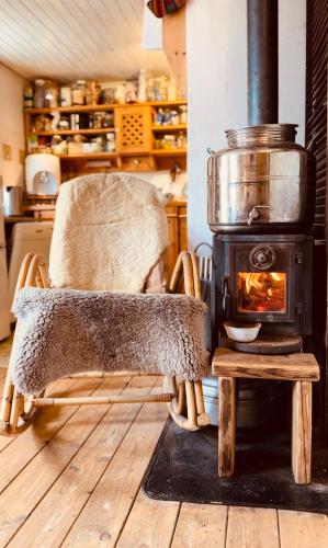 una silla frente a una estufa en una cocina en Zimmer in rustikalem alten Haus, en Tiefenpölz