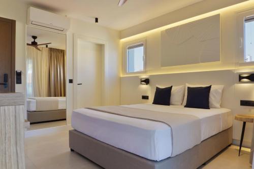 a bedroom with a large white bed in a room at Palm Boutique Suites in Pefkohori