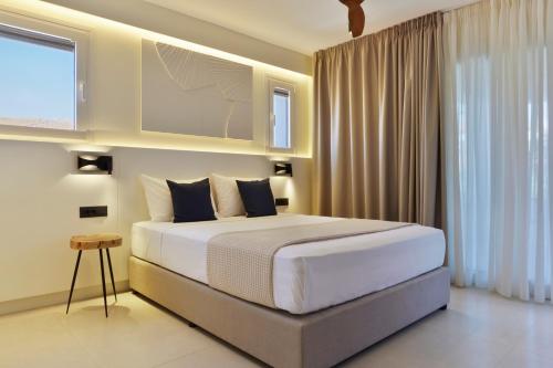 a bedroom with a large bed and a television at Palm Boutique Suites in Pefkohori