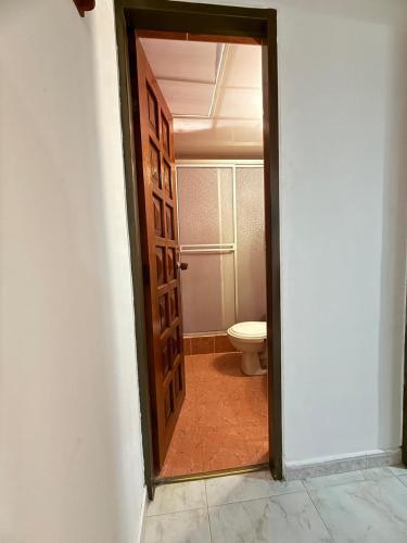 a door leading to a bathroom with a toilet at Casa Alicante Girardot in Girardot