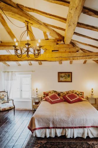 - une chambre avec un grand lit et des plafonds en bois dans l'établissement Cuq en Terrasses, à Cuq-Toulza