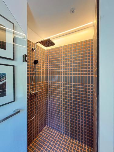 La salle de bains est pourvue d'une douche avec du carrelage brun. dans l'établissement Elegant apartment, Cap de Nice, à Nice