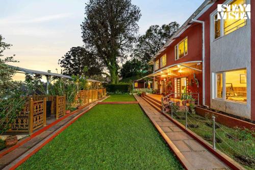 a backyard of a house with a green lawn at StayVista at Lakshmi's Retreat - Kotagiri in Kotagiri