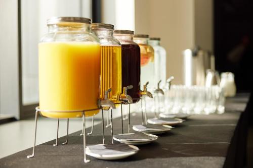 a row of glasses filled with orange juice on a counter at Hotel Mona Plaza in Belgrade