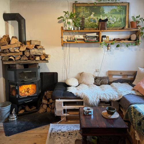 Una sala de estar con un sofá y una estufa de leña. en Zimmer in rustikalem alten Haus, en Tiefenpölz