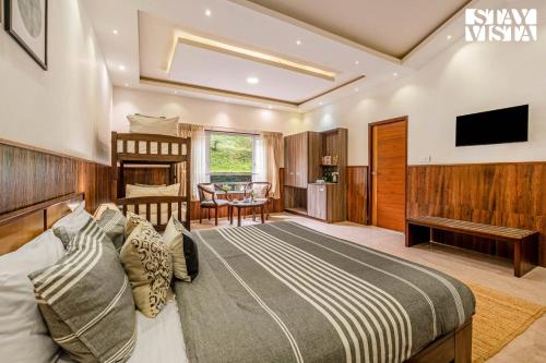 a bedroom with a bed and a living room at StayVista at Lakshmi's Retreat - Kotagiri in Kotagiri