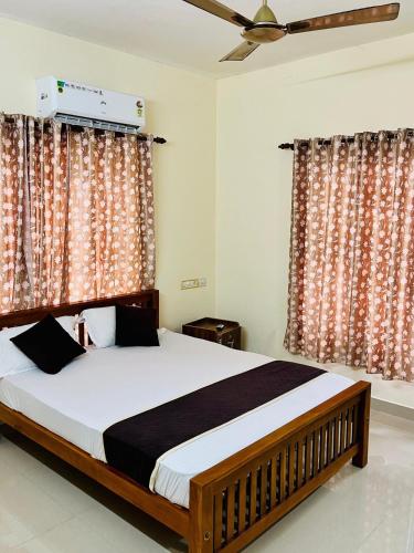 ein Schlafzimmer mit einem großen Bett und Vorhängen in der Unterkunft 3BHK Spacious Villa near Rajagiri Hospital in Ernakulam