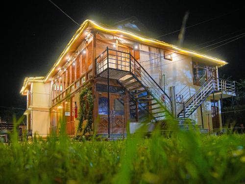 ein Haus mit einer Treppe seitlich in der Nacht in der Unterkunft Moksha Woodhouse in Kasol