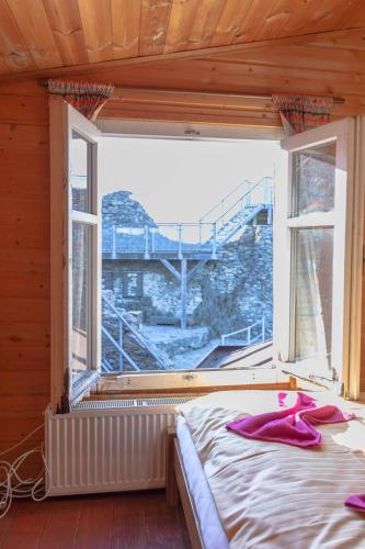 a bedroom with a bed and a window with a view at Hrad Tolštejn - turistické ubytování in Jiřetín pod Jedlovou