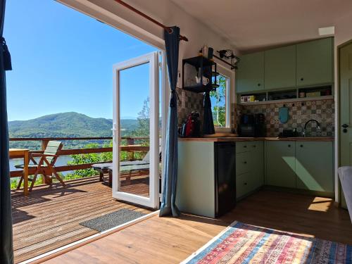 a kitchen with a door open to a balcony at Sherpa Pihenőház in Nagymaros