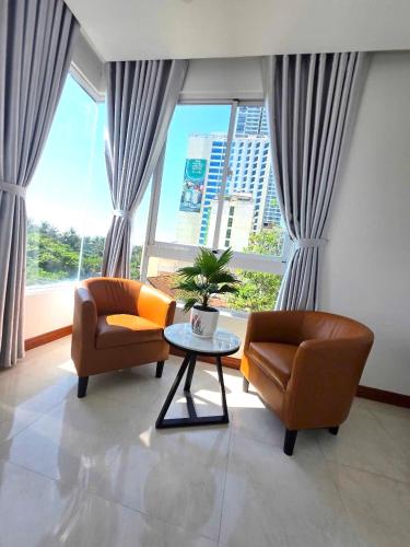 a living room with two chairs and a table in front of a window at Oasis Home in Nha Trang