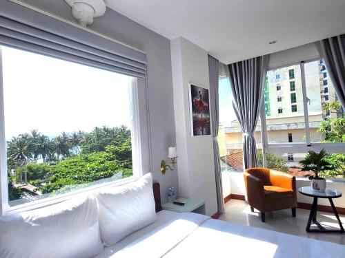 a bedroom with a large window with a couch and a chair at Oasis Home in Nha Trang