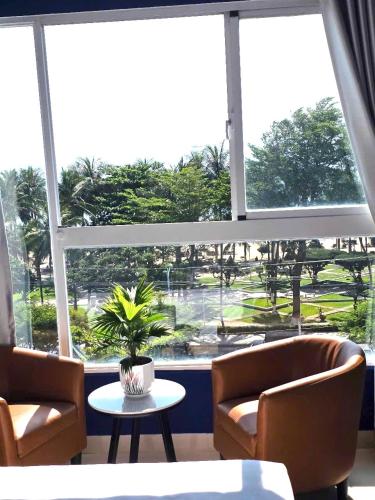 a room with two chairs and a table and a large window at Oasis Home in Nha Trang