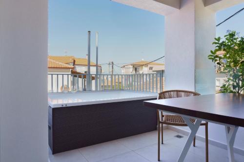 a balcony with a hot tub and a table at Palm Boutique Suites in Pefkohori