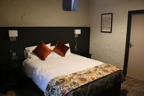 a bedroom with a large white bed with pillows at Black Dog Inn in Bolton