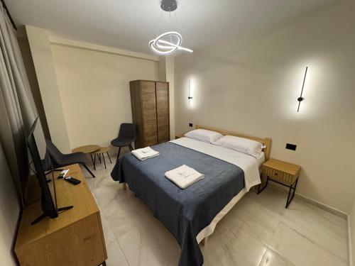 a bedroom with a bed and a desk and a television at Cozy Double Room in City Center in Shkodër