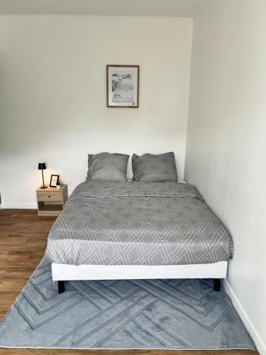 Ce lit se trouve dans une chambre dotée d'un mur blanc. dans l'établissement Maison idéale pour grand groupe, à Villiers-le-Bel