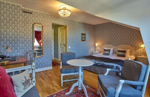 a hotel room with a bed and a table and chairs at Scandic Gamla Stan in Stockholm
