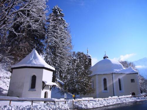 a small white church with snow on it at Alpenflair Ferienwohnungen "Haus Doris" in Oberstdorf