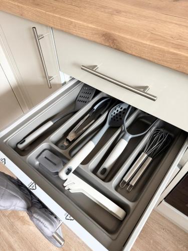 a drawer filled with cooking utensils in a kitchen at Lovely 2 Bed End Terrace - Private Parking - Garden in Cardiff
