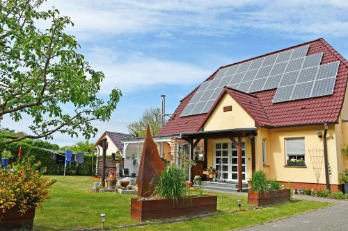 a house with solar panels on the roof at Ferienwohnung Karnitz im Herzen von Rügen in Karnitz